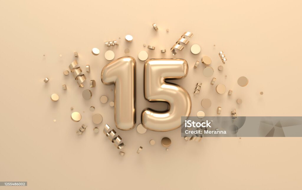 Image 3D représentant le chiffre 15 doré, orné de confettis et de rubans en spirale.